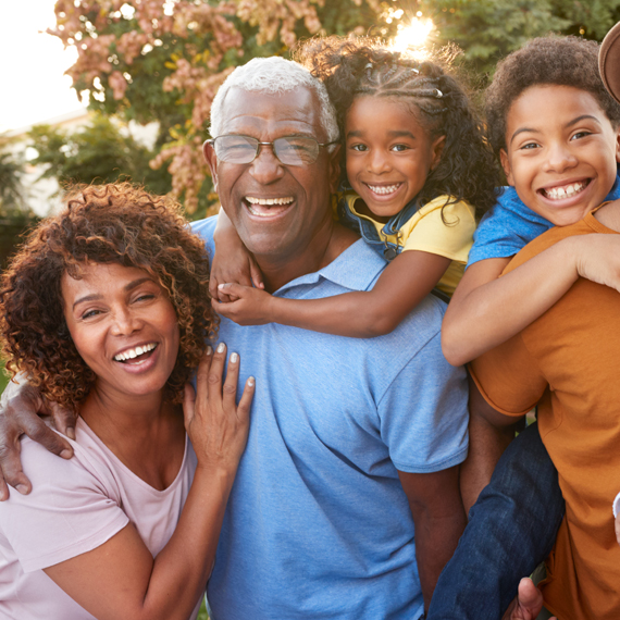 A family standing outside together, laughing and smiling.
