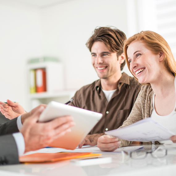 A man and woman sitting together in a meeting with a financial rep.
